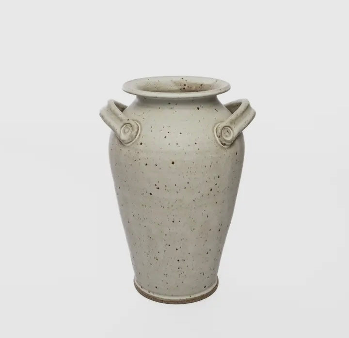 Gray speckled Greek style ceramic vase with handles on a light gray background