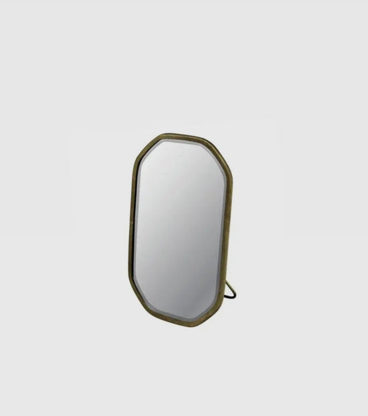 A round beveled glass mirror with a brass frame and built-in easel, suitable for bathroom use.