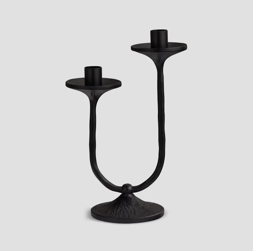 Black metal double candle holder on a light gray background
