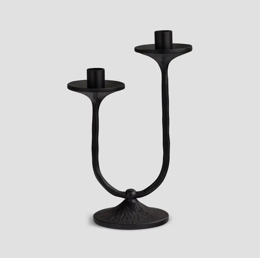Black metal double candle holder on a light gray background