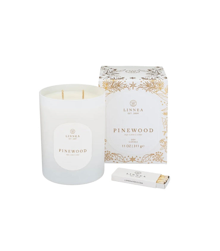 White candle with 'LINNEA' branding and a decorative Pinewood scent.