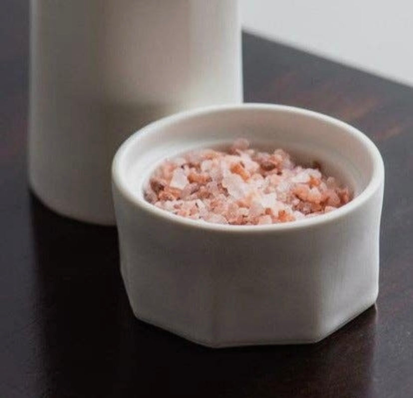 Close-up of porcelain salt cellar paired with Elixir Oil Bottle.
