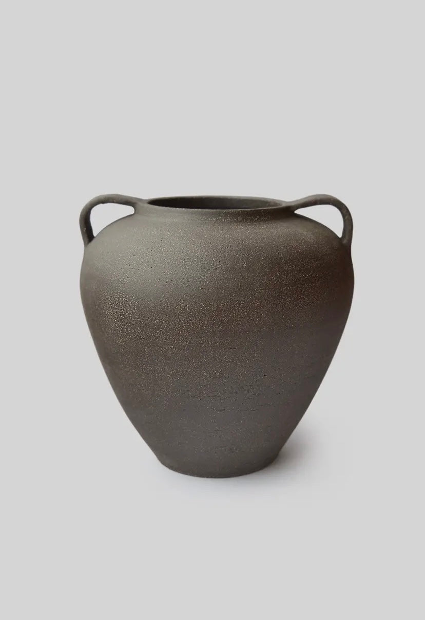 Dark gray ceramic vase with handles on a light gray background