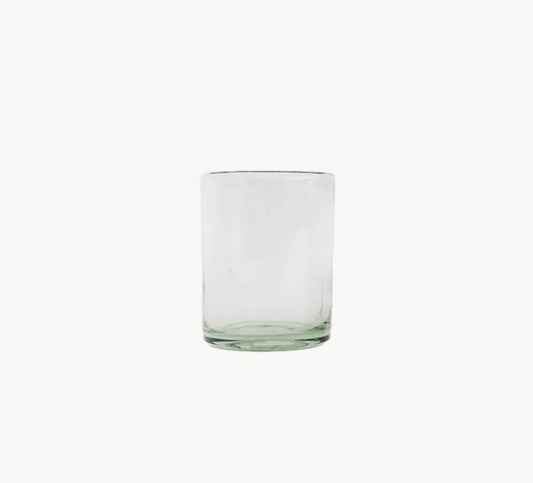 A clear glass with a green tint, cylindrical in shape, on a plain background.