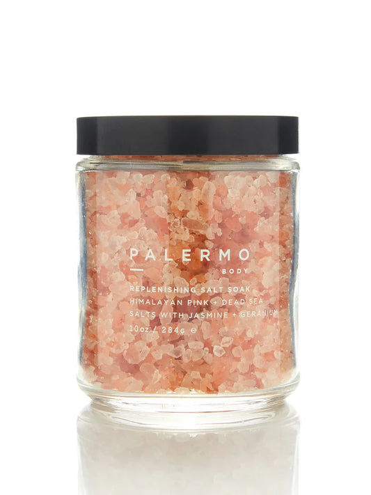 A clear glass jar filled with pink himalayan pink salt, jasmine rice, and dead sea salts, with a black lid and a label that reads 'PALERMO body'.