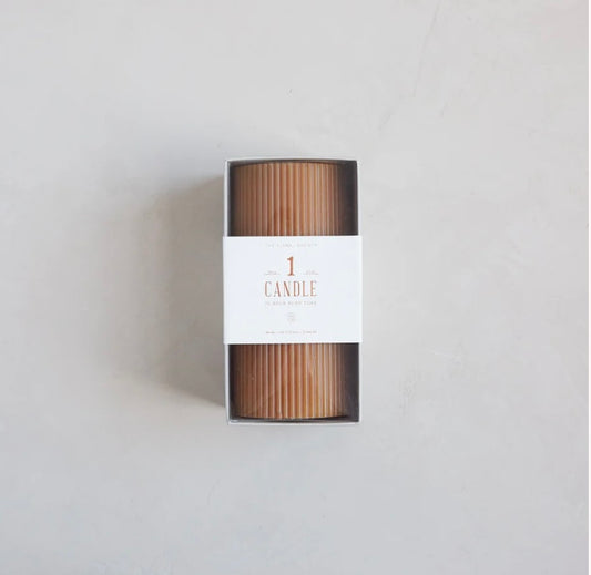 A ribbed pillar candle in a brown color, packaged in a box with the label '1 CANDLE' and 'RIBBED PILLAR CANDLE'.