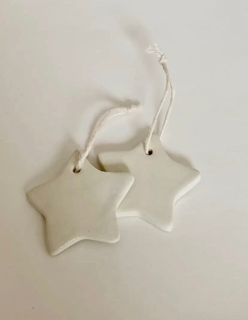 Two star-shaped ceramic ornaments on a white background