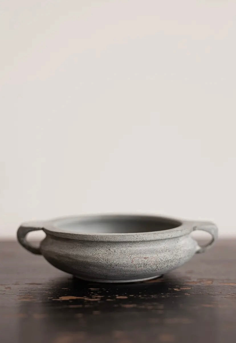 Grey soapstone bowl on table.