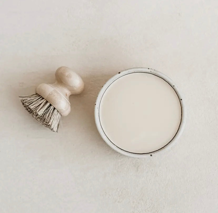 Round ceramic dish filled with solid dish soap viewed from aboth with wooden scrubbing brush.  (Brush sold separately.)