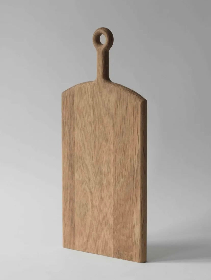 Wooden cutting board with handle on a gray background