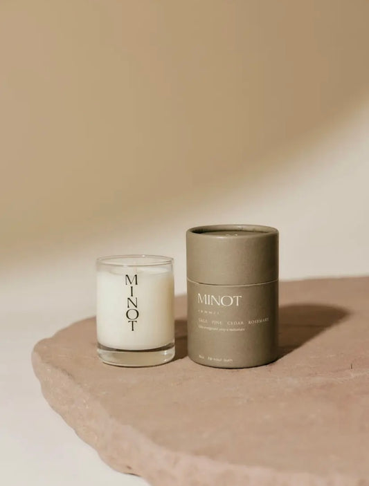 Candle and its packaging with 'MINOT' branding on a neutral background