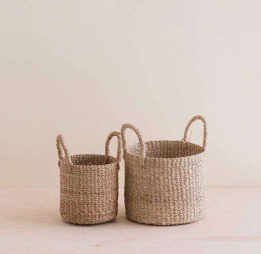 Two woven baskets made of Manila Hemp, one small and one large, with handles, displayed against a neutral background.