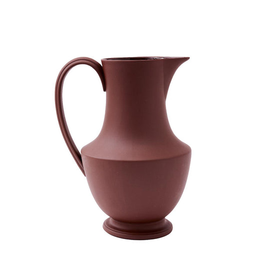 A brown ceramic pitcher with a handle, made of stoneware and suitable for hand wash.