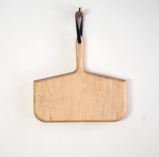A maple wood cutting board with a balck handle and a hanging loop, displayed against a white background.