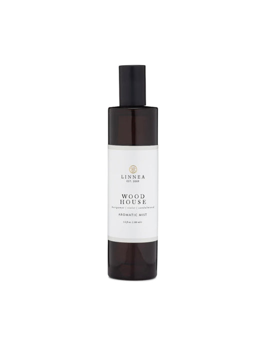 A white spray bottle with a black cap labeled 'Wood House Aromatic Mist LINNEA' on a plain background.