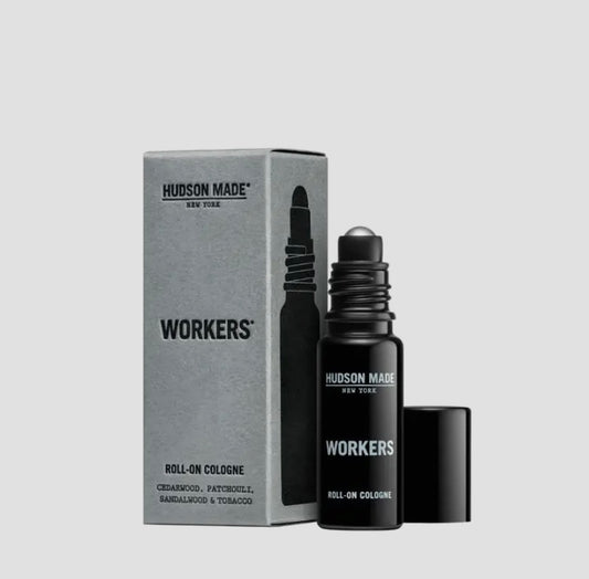 A black roll-on cologne bottle with a dropper, next to its packaging box which reads 'Hudson Made Workers Roll-On Cologne'. The background is white.