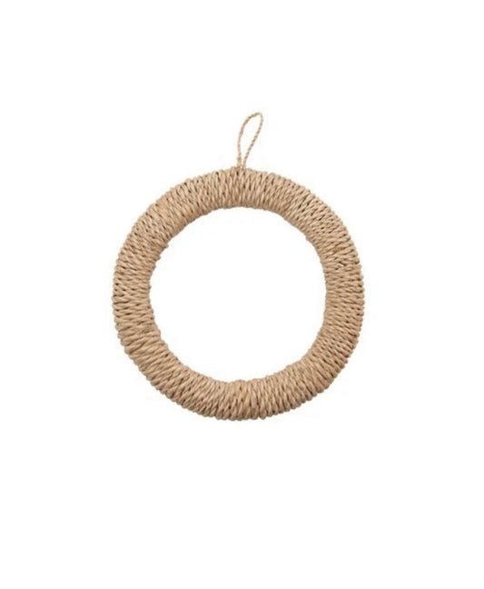 A woven round trivet with a loop for hanging at the top.