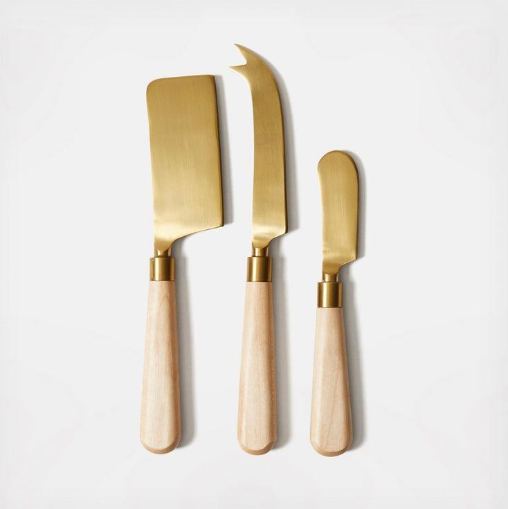 Three piece set of cheese knives with brass blades and wooden handles.