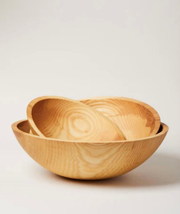 A hand-carved wooden bowl with a natural finish, displaying the grain of the wood.