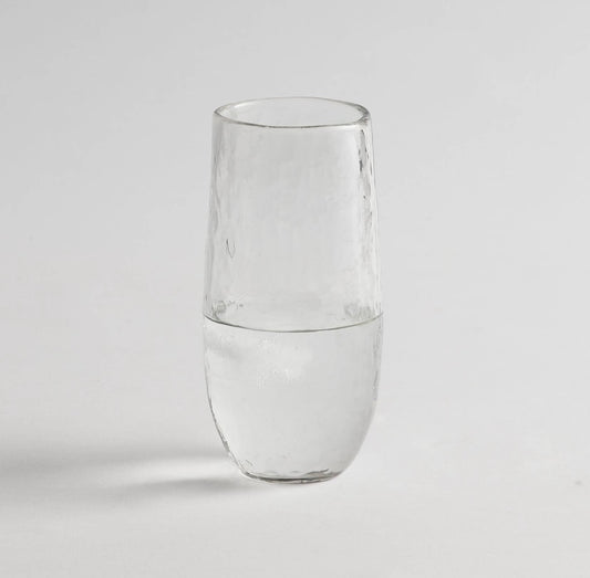 Close-up of handcrafted drinking glass showing textured surface and rounded shape