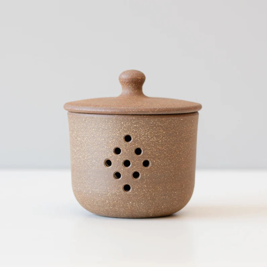 Handmade ceramic garlic jar with vent holes and lid.