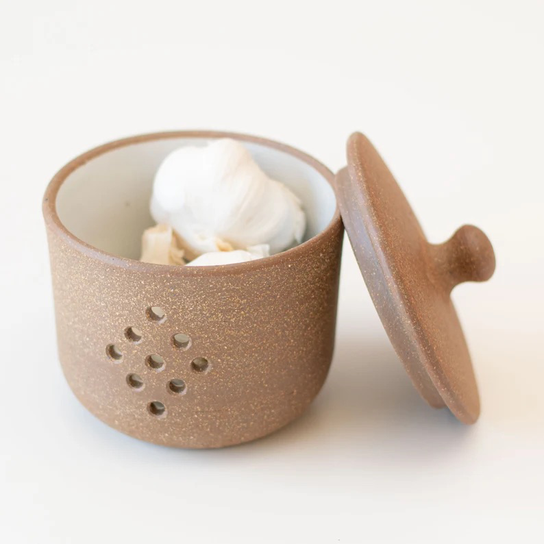 Close-up of ceramic garlic storage jar showing subtle handmade texture with garlc